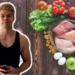 Fit man standing next to raw healthy food as example of wellness