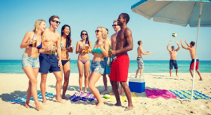 ESL grammar visual for English A2 level: A group of diverse friends at a sunny beach party, used to practice 'was' and 'were' past tense vocabulary.